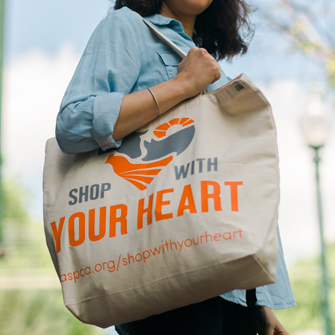 Person holding Shop With Your Heart tote bag